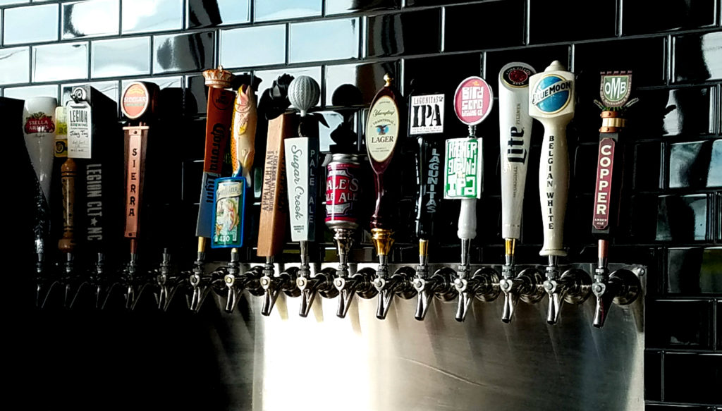 16 beers on tap in a row. Many local ones to choose from. Trendy black subway tile on the backslash of the bar.